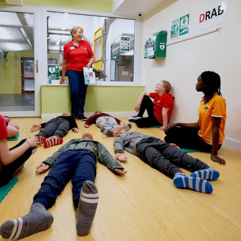 A Life Skills volunteer with children A Life Skills volunteer teaches some local children first aid.